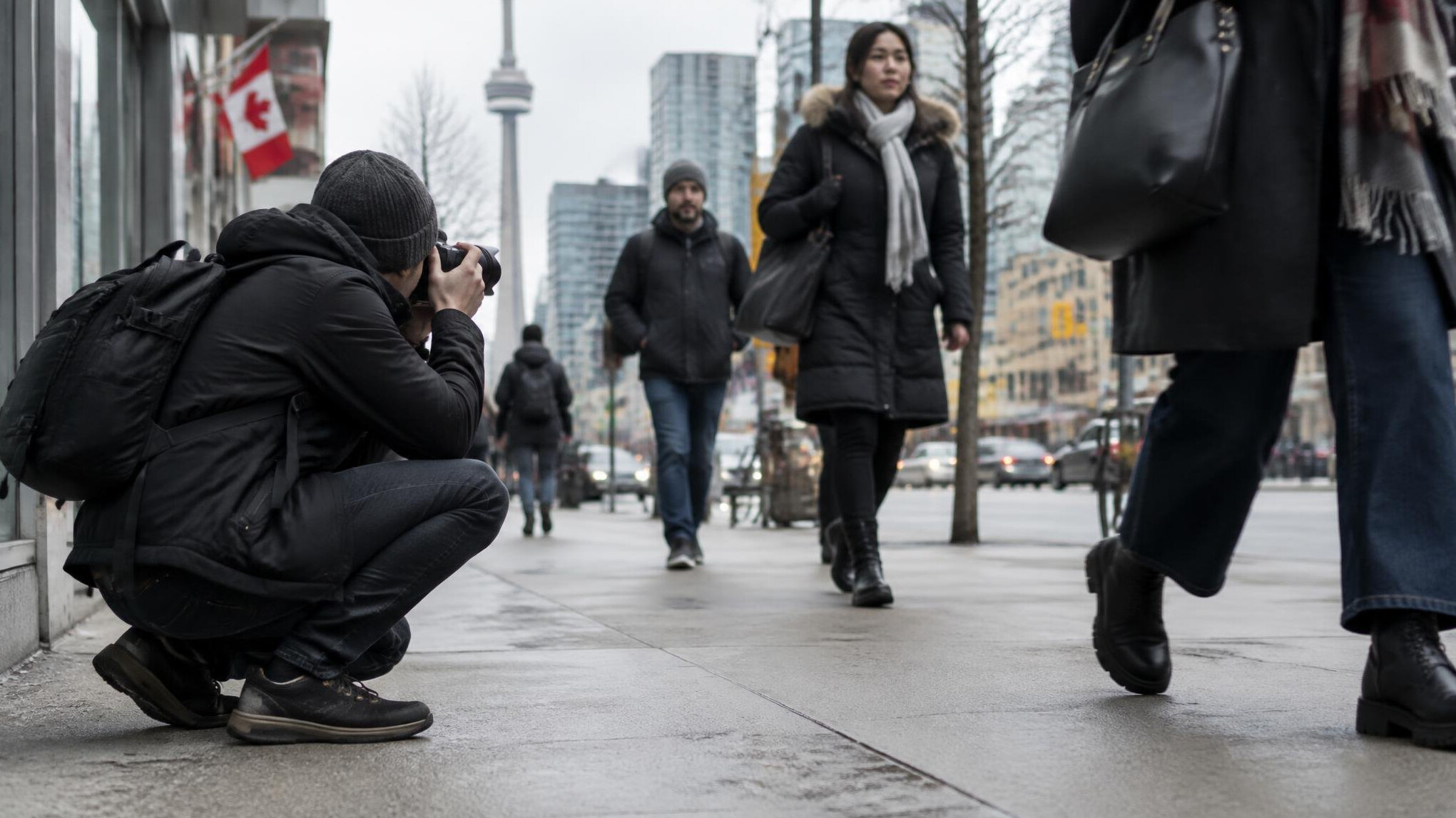 Photographer crouched capturing a street scene in the city